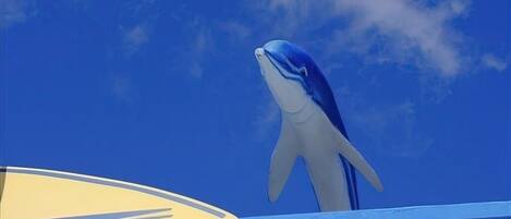 Une grande statue de baleine se détachant sur un ciel bleu clair.