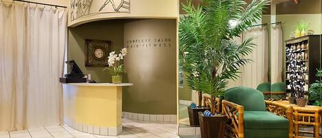 A salon with a reception desk, a clock, and a wall with 'BODY' and 'COMPLETE SALON HAIR FITNESS' text.