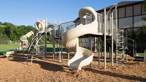 Un parque infantil con un tobogán en espiral y estructuras para escalar.