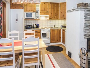Une cuisine avec des meubles en bois, une cuisinière blanche et un four à micro-ondes.