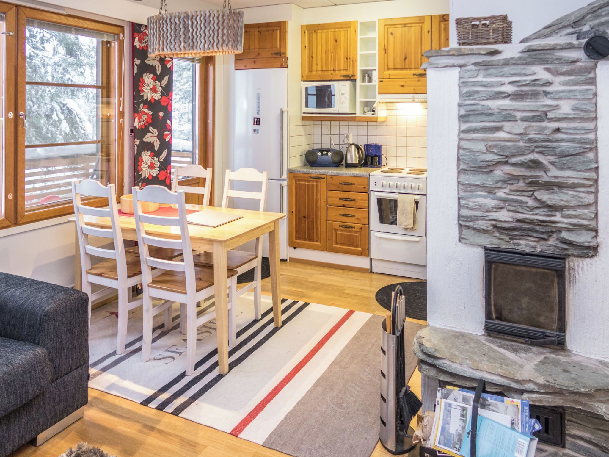 A cozy interior with a dining area, kitchen, and fireplace.