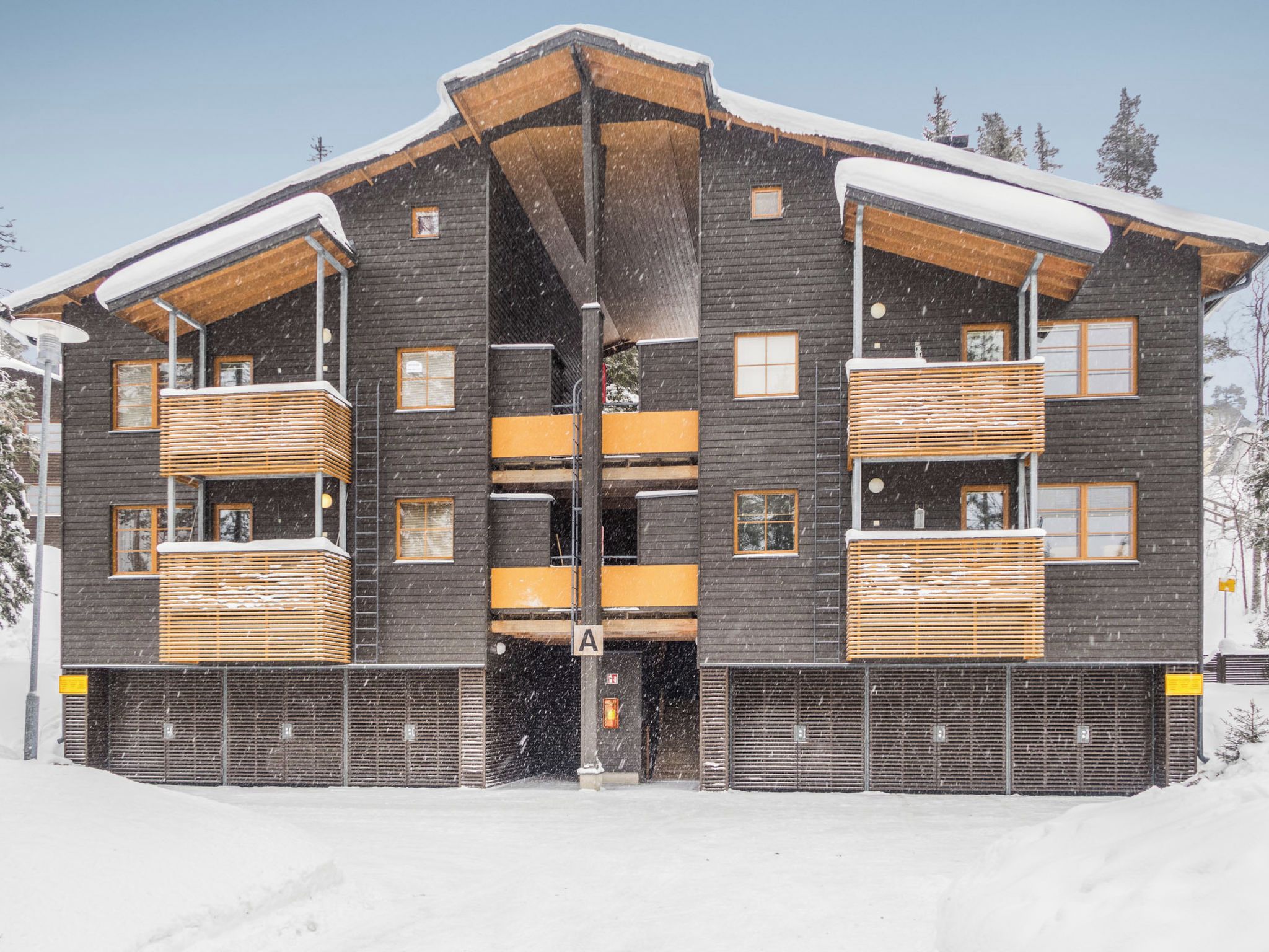 A multi-story building with a symmetrical facade, wooden balconies, and a central entrance.