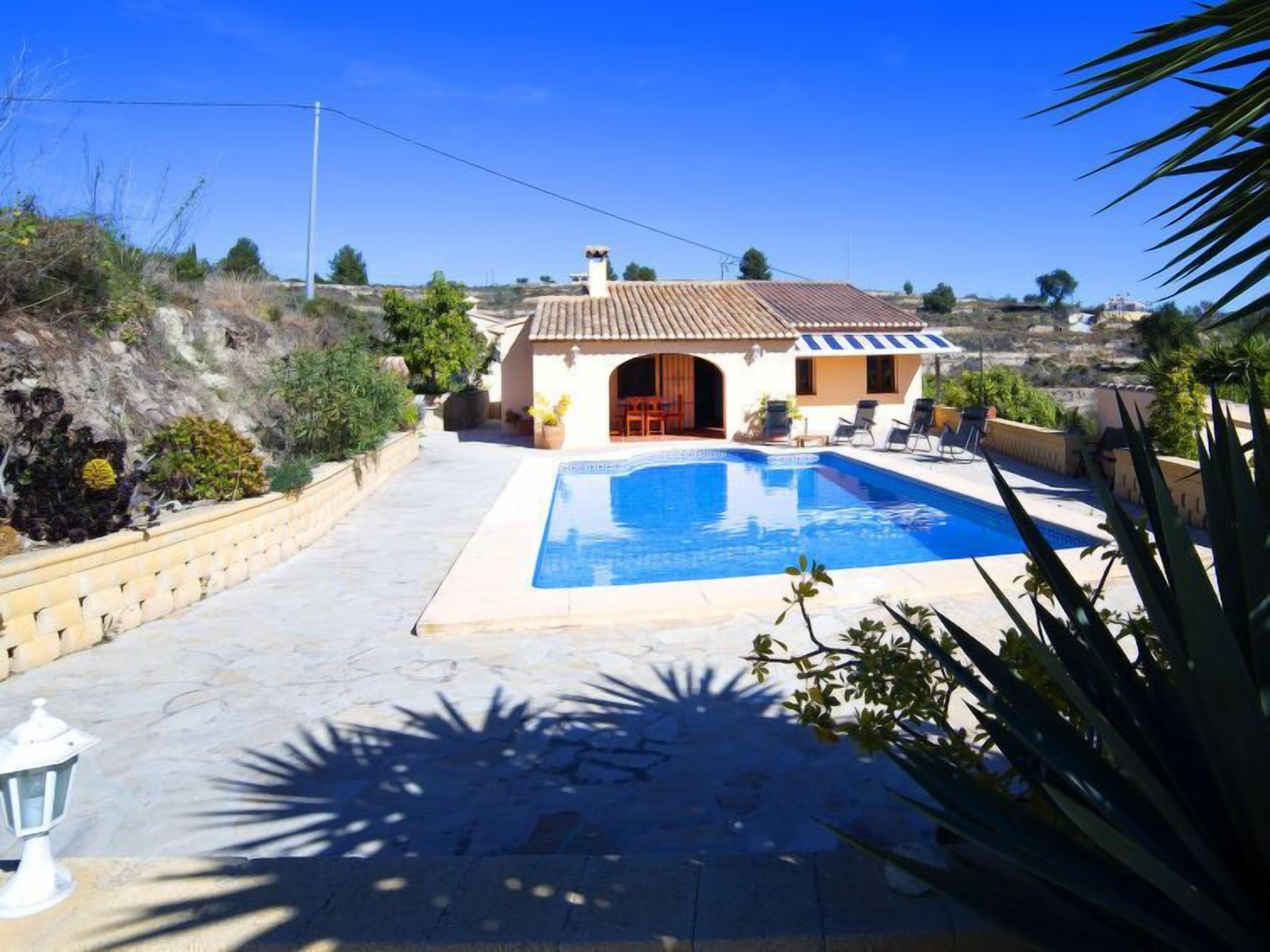 Ein Haus mit Swimmingpool, Terrasse und Blick auf die umliegende Landschaft.