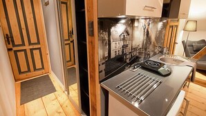 A compact kitchen with a modern stove, a sink, and a small dining area.