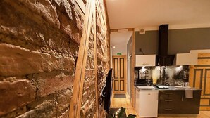 A modern kitchen with wooden accents and a stone wall.