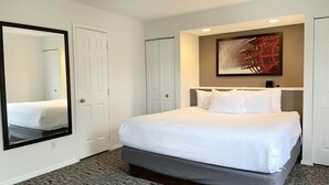 A hotel room with a large bed, a mirror, a painting, and a wardrobe. - Spacious Branson  lodging with Beautiful scenery (Branson)