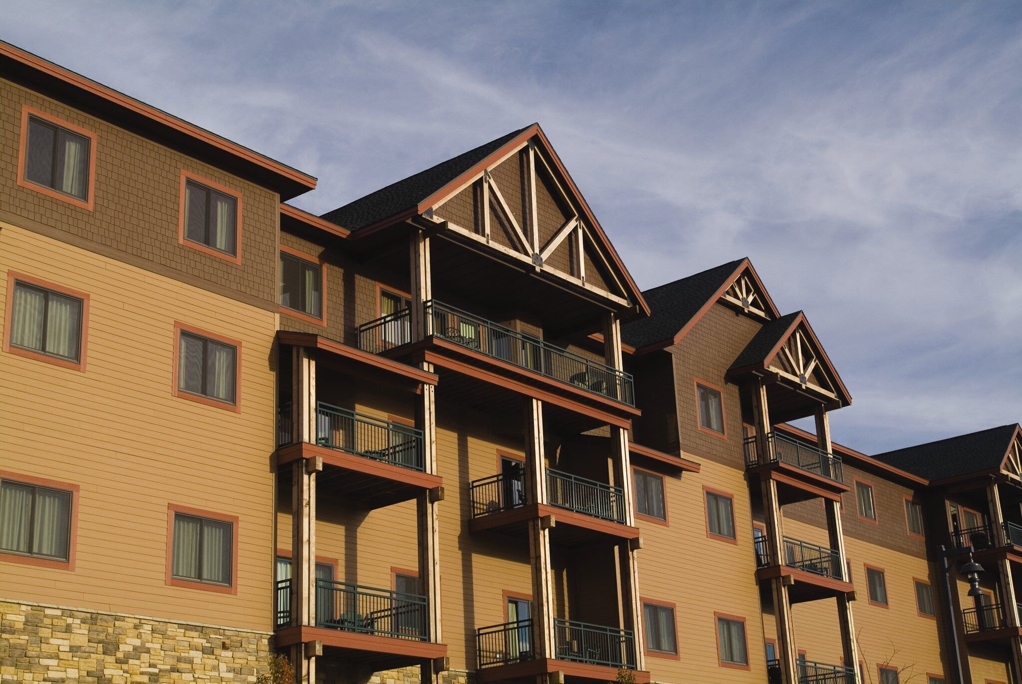 A multi-story hotel with balconies, a stone facade, and a clear sky.