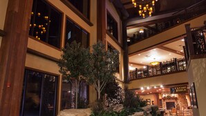 A spacious lobby with a central rock feature, leather seating, and a chandelier.