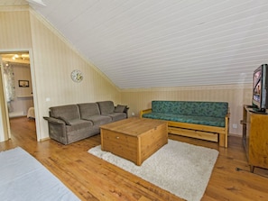 A loft-style living room with a wooden ceiling, a sofa, a loveseat, and a coffee table. - Honkaniemi by Interhome (Joensuu)