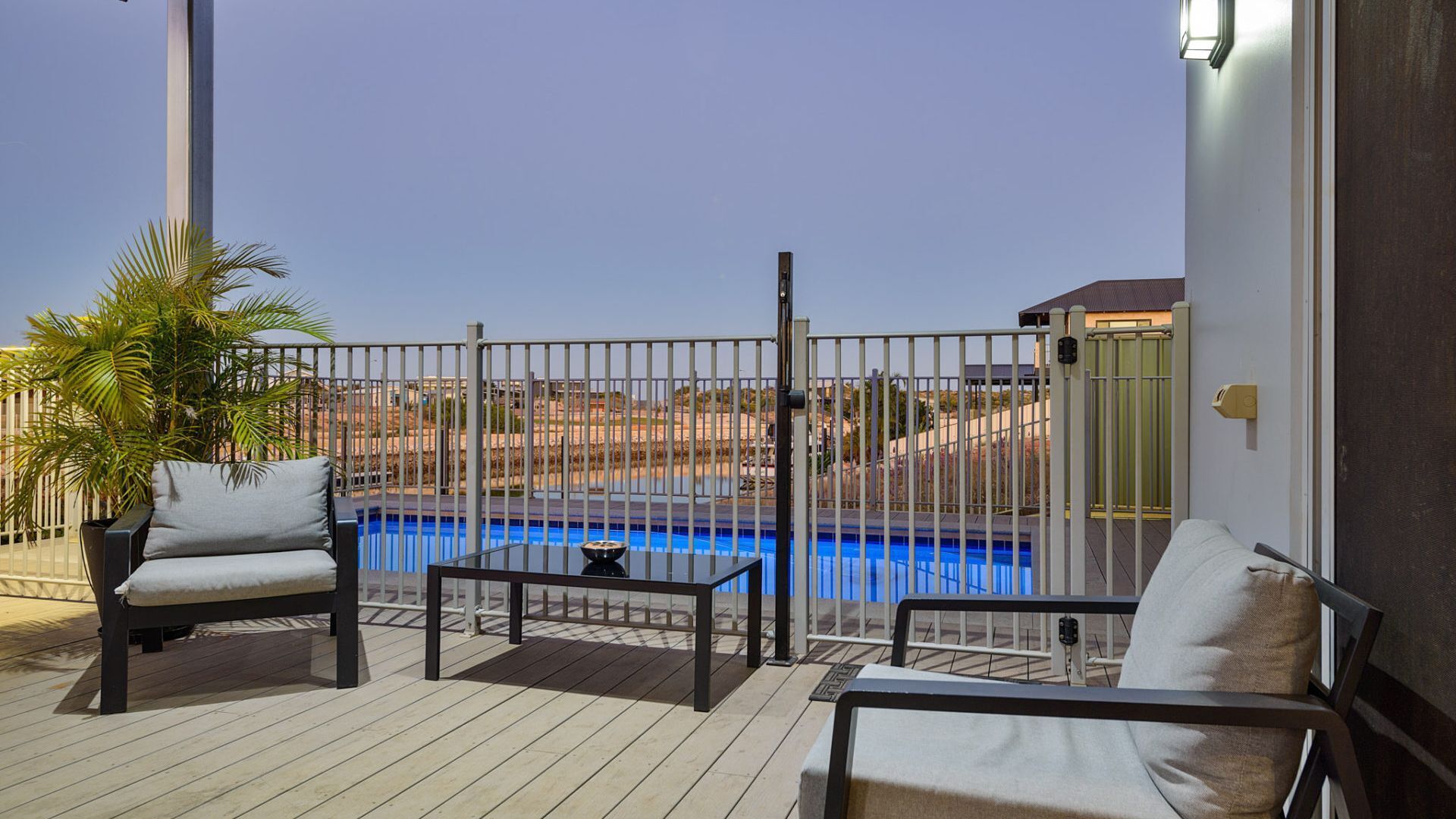 Eine Terrasse mit zwei Sofas und einem Tisch mit Blick auf einen Swimmingpool.
