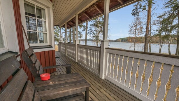 Une terrasse en bois, dotée de bancs et d’une rambarde, qui offre une vue sur une étendue d’eau.