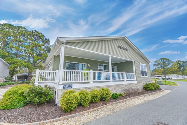 A single-story house with a porch, a mailbox, and a clear sky.