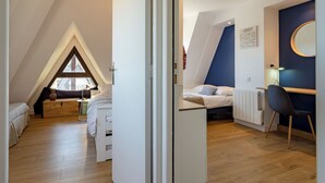 Un dormitorio estilo loft moderno con techo inclinado, un escritorio y una silla.