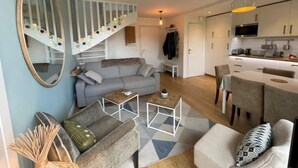 Un apartamento moderno con escaleras, sala de estar, comedor y cocina.