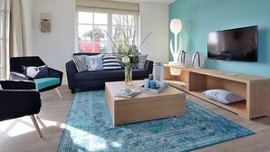 Uma sala de estar moderna com sofá, mesa de centro e televisão.