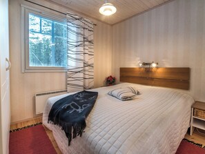 A bedroom with a bed, a window with blinds, a wall-mounted light fixture, and a radiator. - Vacation home Siula by Interhome (Enontekiö)