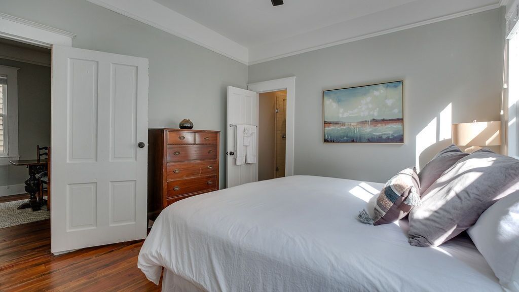 Un dormitorio con una cama grande, un aparador y un cuadro en la pared.