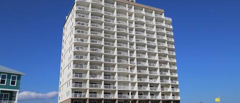 Un hotel de varios pisos con balcones, cerca de una playa.