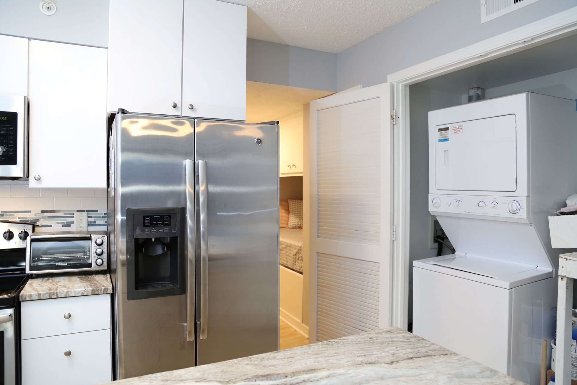 A modern kitchen with stainless steel appliances, a built-in oven, and a water dispenser.