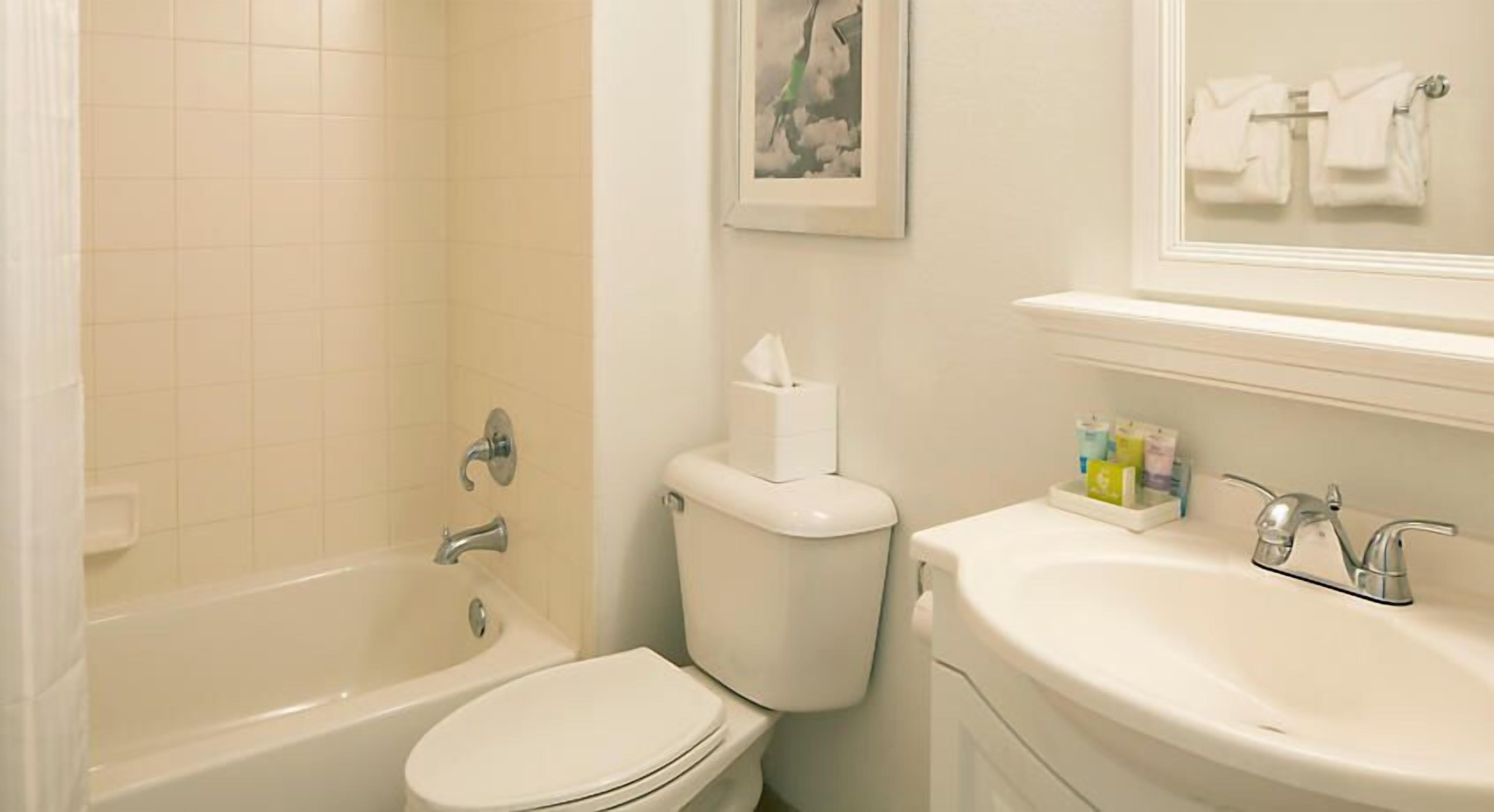 A bathroom with a bathtub, toilet, and sink.