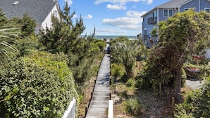 A wooden boardwalk leading to a house with a view of the ocean. - Oceanfront duplex with direct beach access (Emerald Isle)