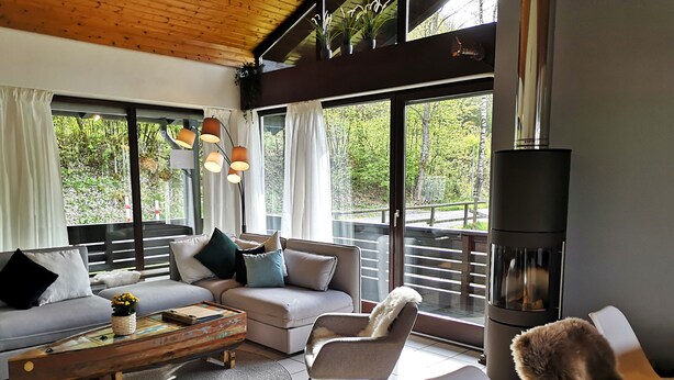 Uma sala de estar moderna com sofá, poltronas, mesa de centro e lareira.