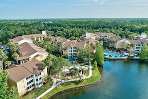 A resort with multiple buildings, a swimming pool, and a lake.