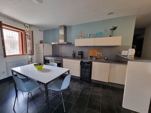 A modern kitchen with a white dining table, blue chairs, and a dishwasher. - Apartment in Collioure center with terrace & WiFi (Collioure)