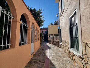A narrow alleyway with stone pavement, arched doorways, and barred windows. - Apartment in Collioure center with terrace & WiFi (Collioure)