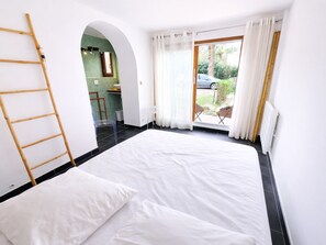 A room with a bed, a ladder, a small table, and a view of the outside. - Apartment in Collioure center with terrace & WiFi (Collioure)