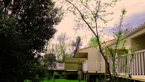 Ein Wohngebiet mit einem Haus, einer Holzterrasse und einem umzäunten Garten.