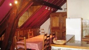 Une cuisine rustique avec des meubles en bois, un plan de travail en pierre et une table avec des chaises.