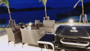 An outdoor seating area with wicker chairs and a grill. - Thalassa Beach and Pool Villa (Yoron)