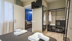 A hotel room with a bed, a walk-in closet, a TV, and a view of the living area. - Cool Jazz 11 - Habitat Apartments (Barcelona)