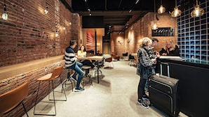 A modern cafe with brick walls, wooden tables, and hanging pendant lights. - Cool Jazz 11 - Habitat Apartments (Barcelona)