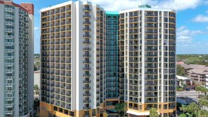 A high-rise hotel with multiple balconies, a swimming pool, and a poolside lounge area. - Beautiful Oceanfront, Full Kitchen, Pet Friendly (Myrtle Beach)
