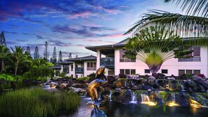 Ein Resort mit Wasserspiel, Palmen und einem Gebäude mit Balkonen.
