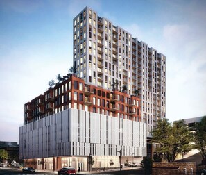 A modern high-rise building with a mix of residential and commercial spaces, featuring a prominent glass facade and a lower section with a unique brick design. - DOWNTOWN Austin with ROOFTOP Pool and BBQ Area, Fire Pit & a Fitness Center (Austin)