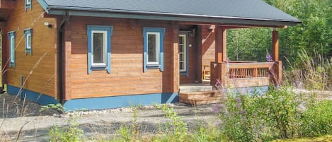 Une cabane en bois avec un porche et une zone abritée.