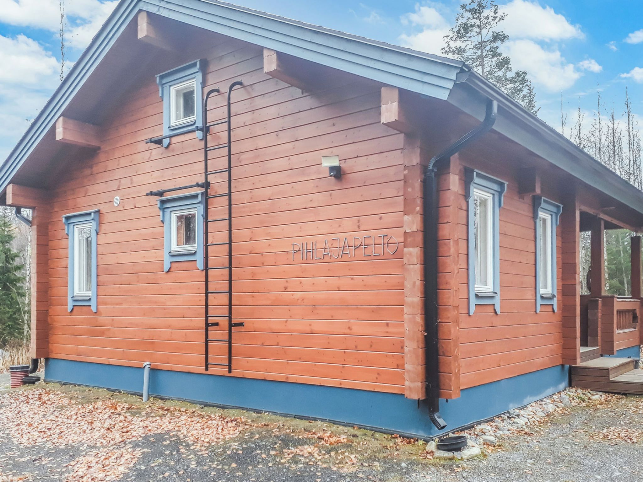 A wooden building with a nameplate, a ladder, and a porch.