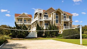 A large, multi-story hotel with balconies and a tennis court in front. - Coastal Castle: Pool, Dog-friendly, Separate Guest House, 530 Ft to Beach (Corolla)