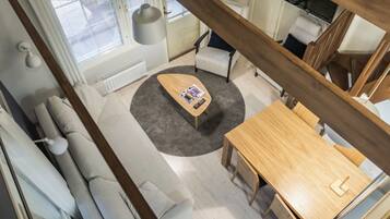Una sala moderna con sofá, una mesita de centro y una mesa de comedor.