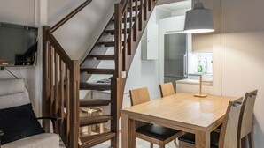 A modern kitchen with white cabinets, a stainless steel refrigerator, and a window with a view of the outdoors. - Mustikka by Interhome (Sotkamo)