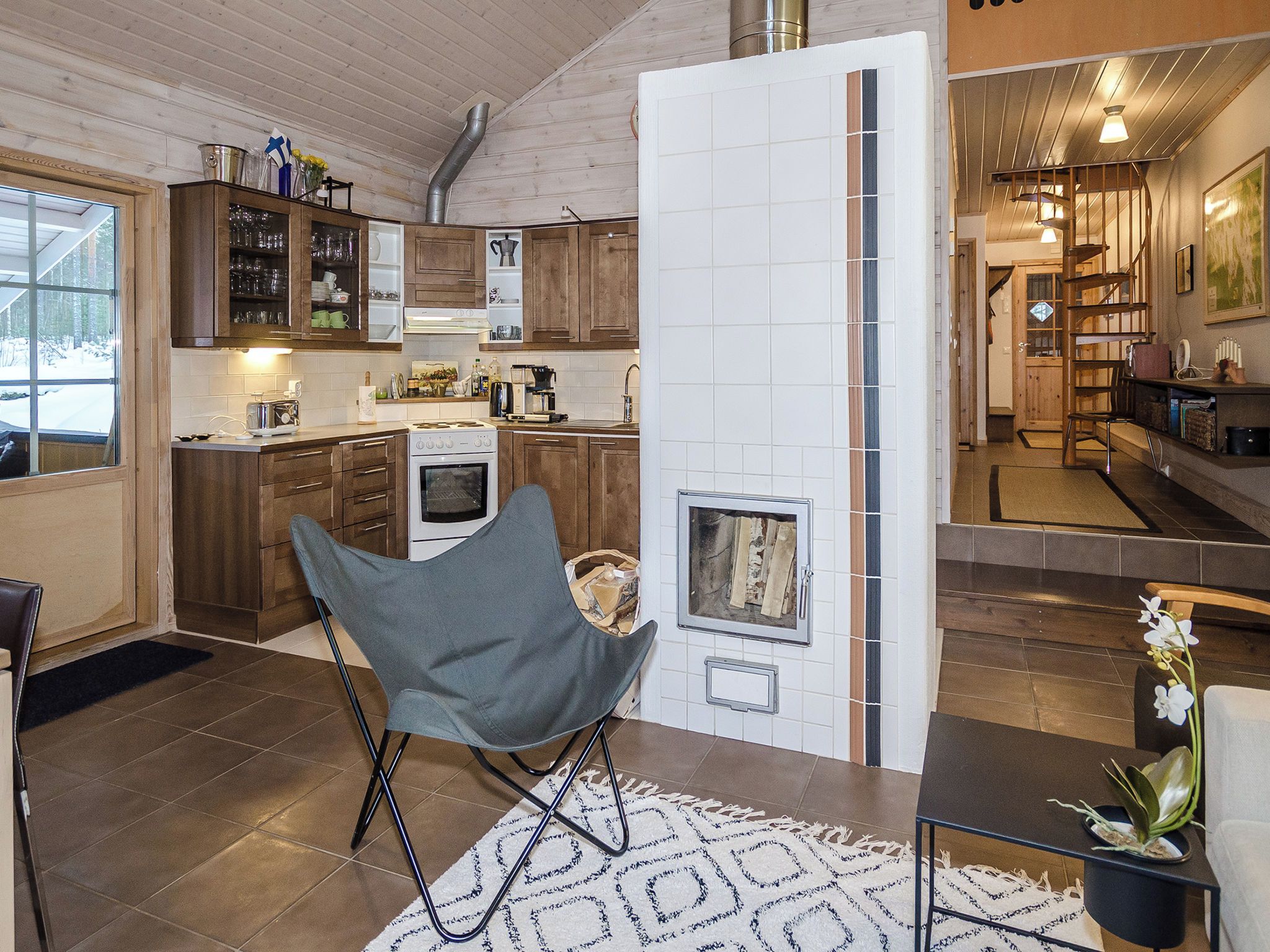 A modern kitchen with wooden cabinets, a built-in oven, and a large window.
