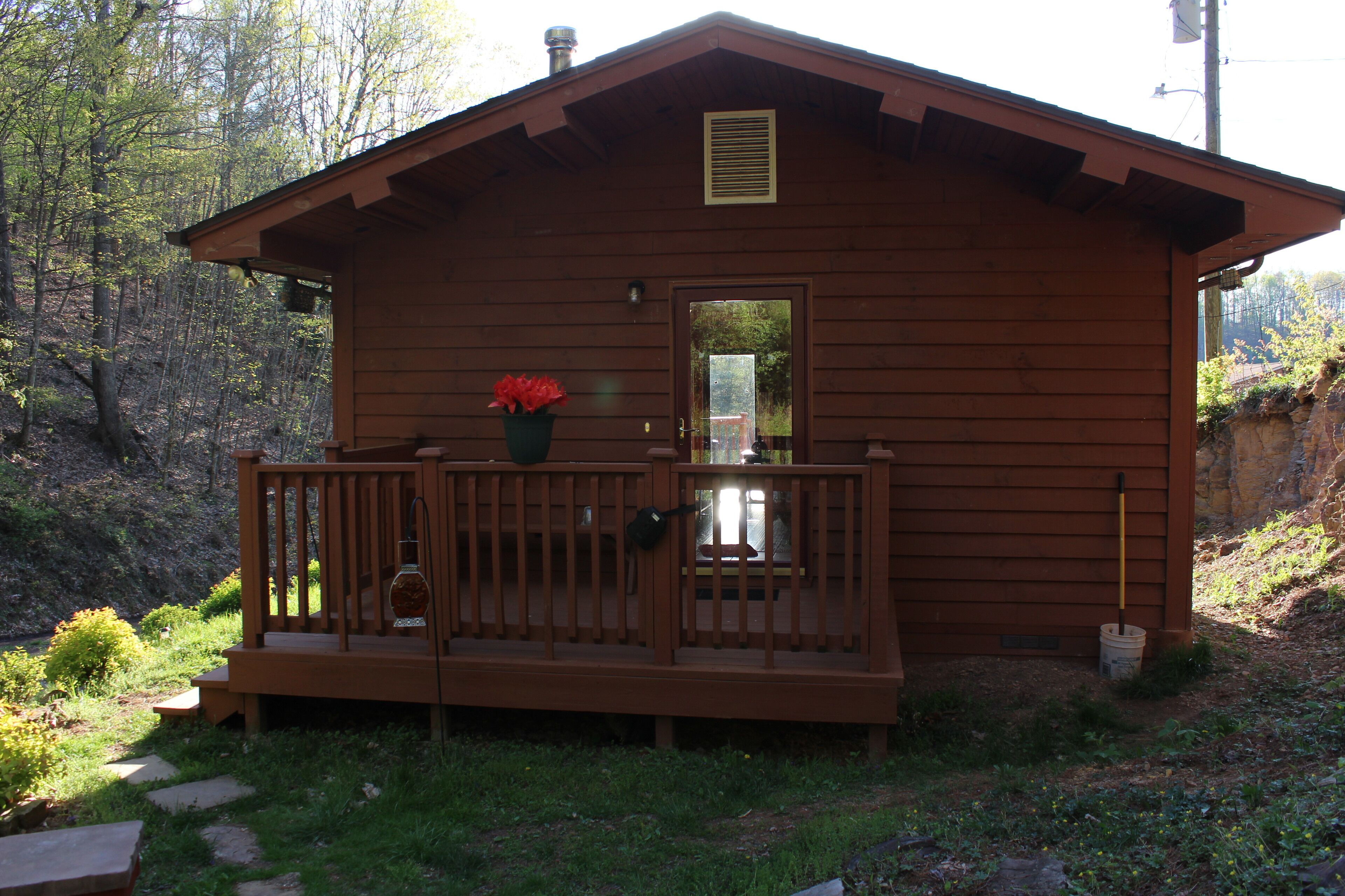 A wooden cabin with a porch, a small window, and a door.