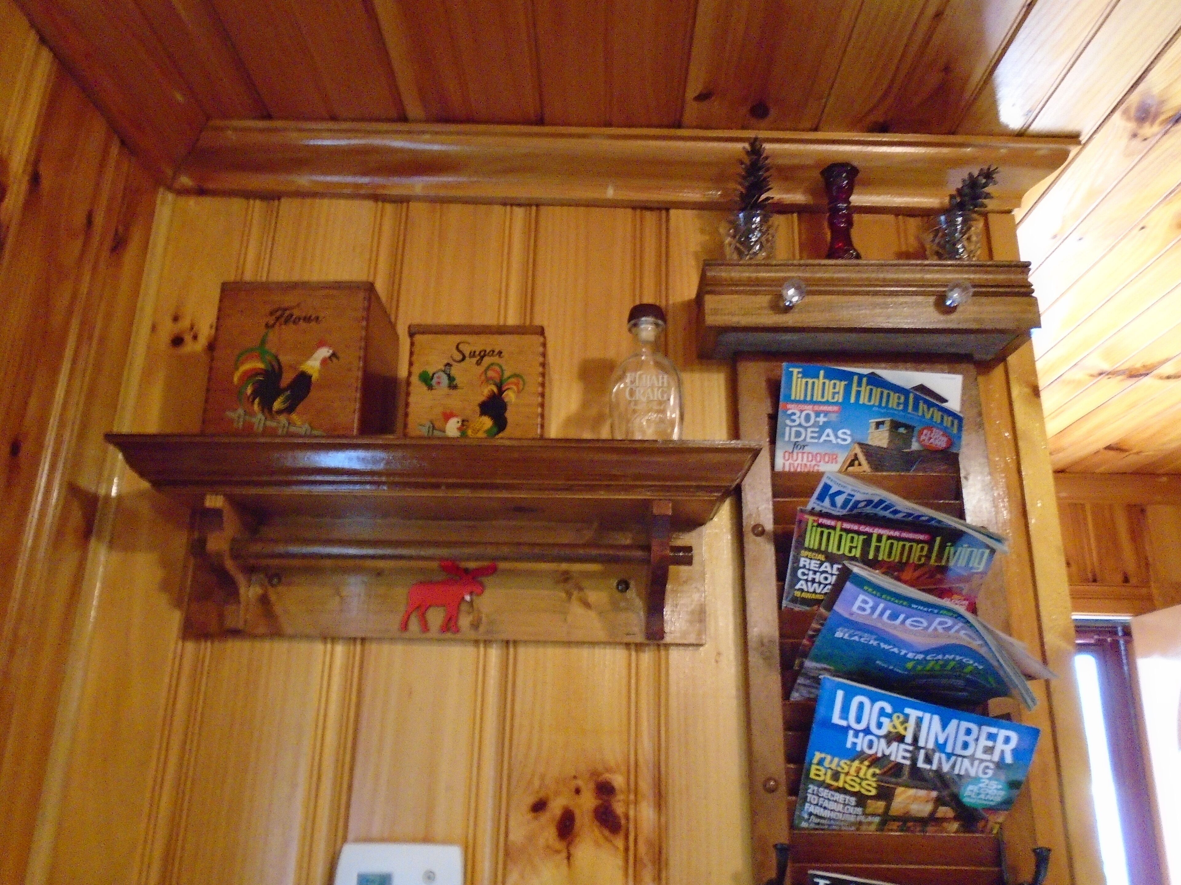 A wooden shelf with kitchen items and magazines.