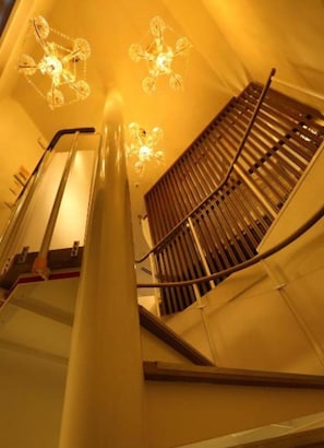 Un escalier en colimaçon, doté d’une main courante et d’une rampe métallique, menant à l’étage supérieur.