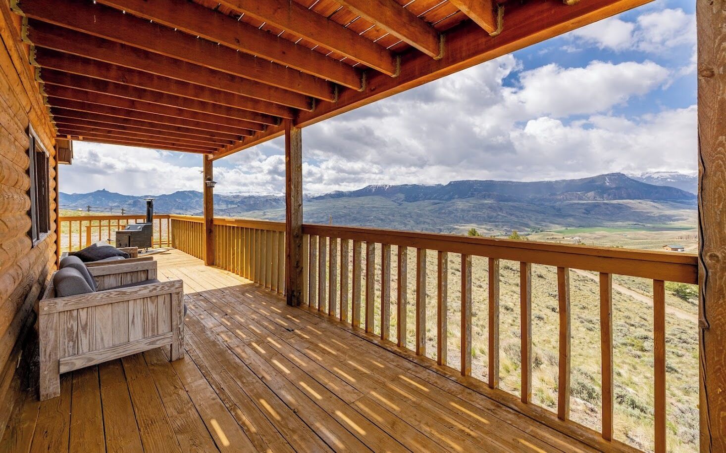Um deck de madeira com vista para montanhas.