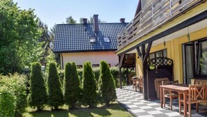 A house with a checkered outdoor patio, a yellow exterior, and a blue roof.