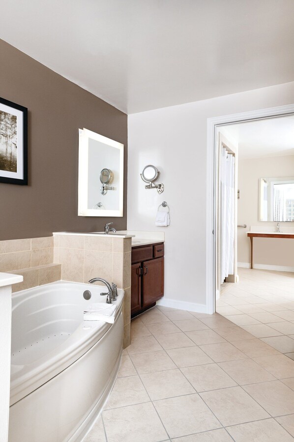 A modern bathroom with a bathtub, two sinks, and a vanity.